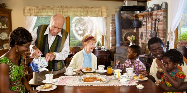 People of different ages and races enjoy refreshments together; the sketch of an angry lion looks in the window