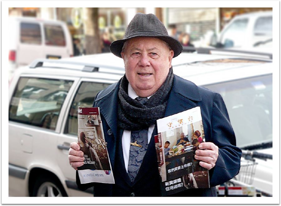 Corwin Robison holds up Chinese literature on a street in Brooklyn, New York
