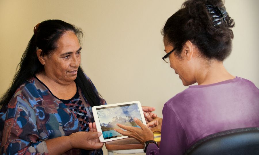 Agnès, a pioneer in New Caledonia, shows her physiotherapist a video