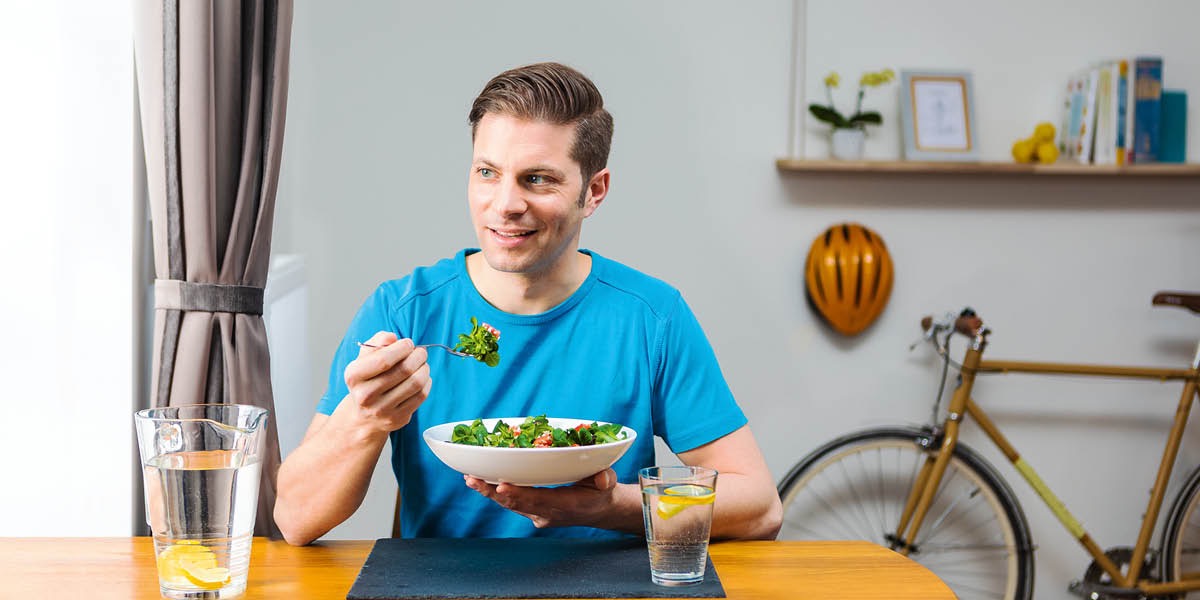 Un hombre comiendo ensalada