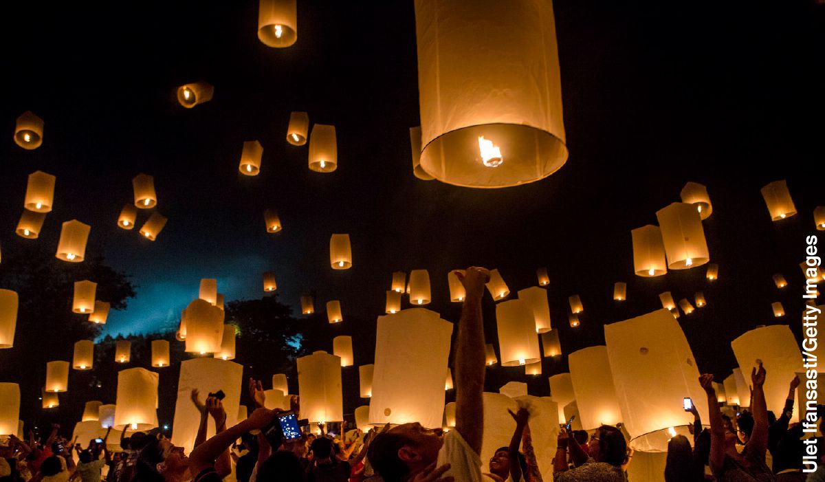 Personas observando cómo ascienden los farolillos de papel que se lanzan durante la fiesta de Vesak