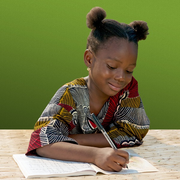 Una niña escribiendo su nombre en su cancionero