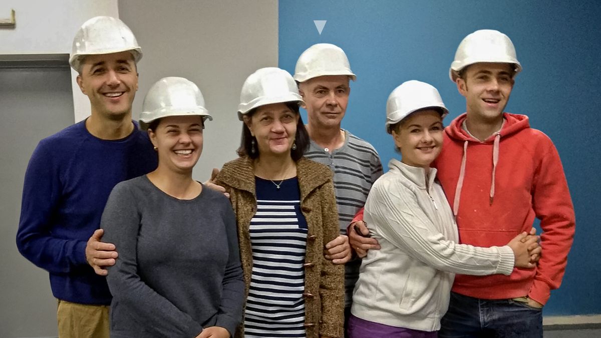 Oleg y su familia usando cascos en la construcción de un Salón del Reino.