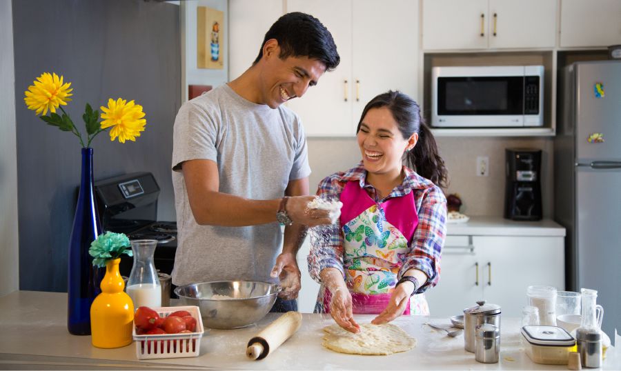 Un esposo y su esposa disfrutan cocinando juntos