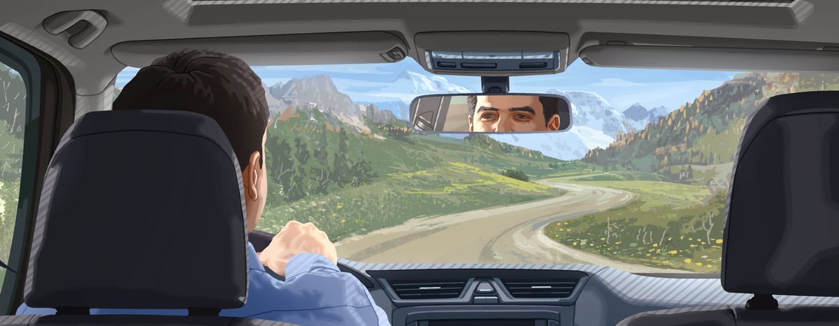 Un hombre que va conduciendo por un camino lleno de curvas mira el espejo retrovisor.