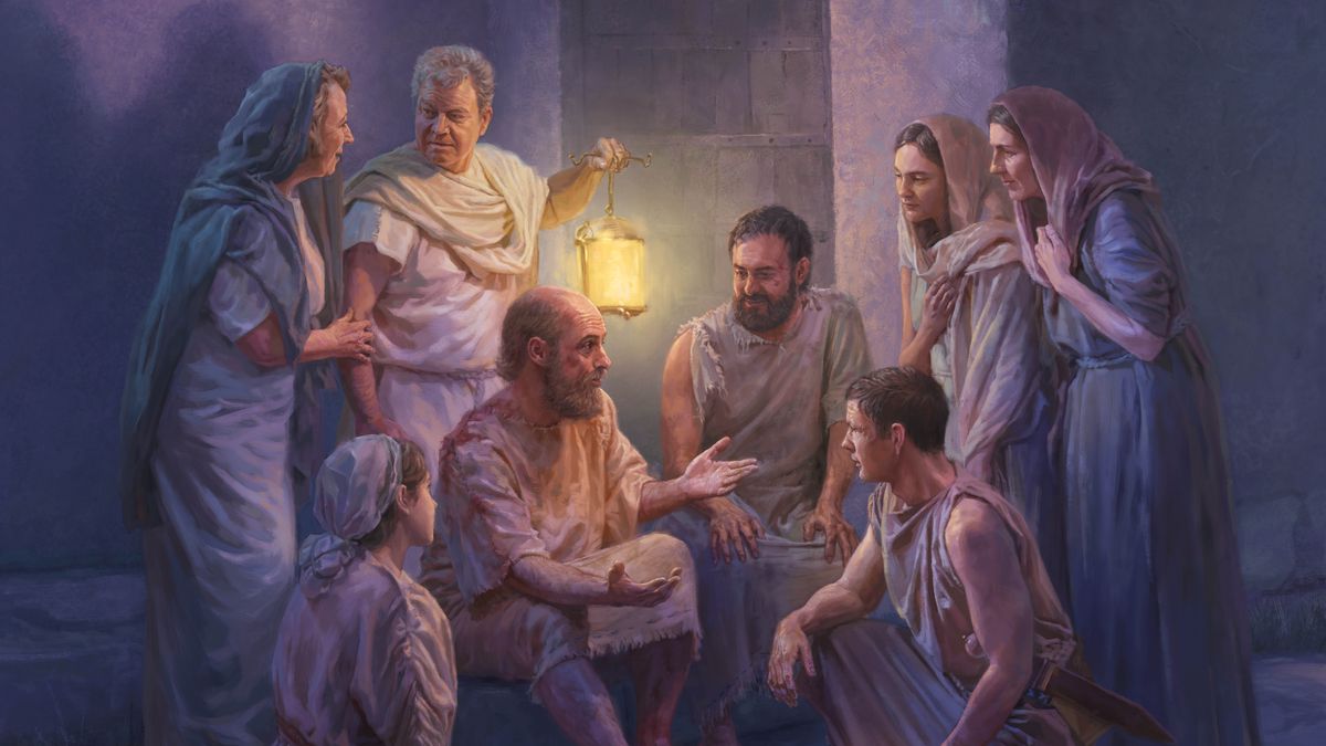Es de noche y Pablo y Silas les predican a un carcelero y a su familia, quienes los escuchan con atención.
