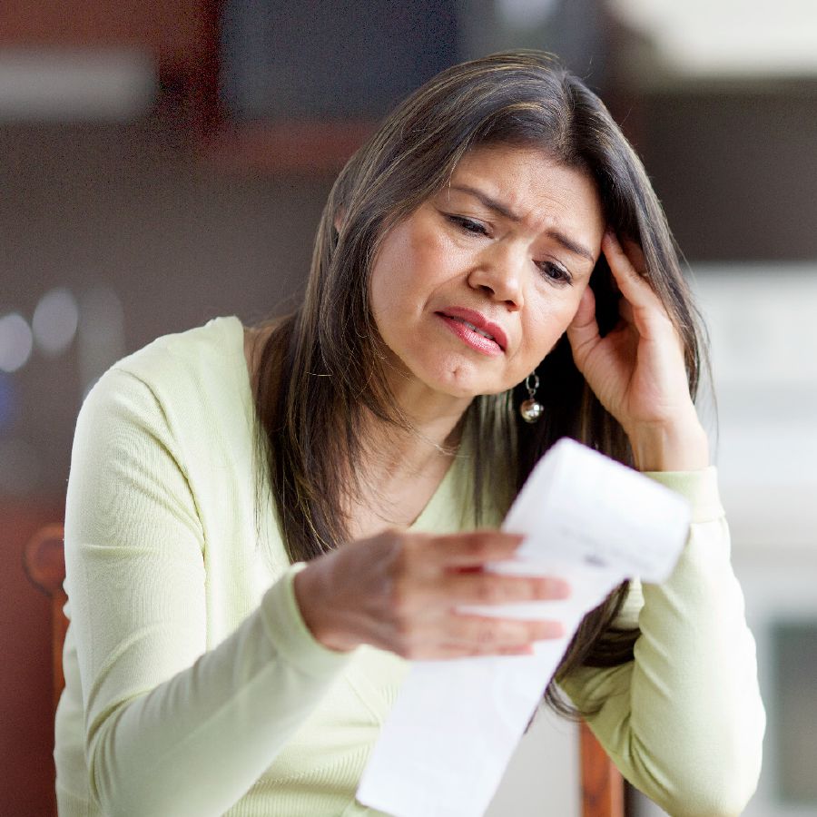 Una mujer mirando preocupada una factura