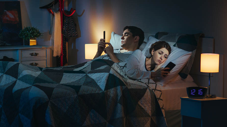 زن و شوهری دیروقت روی تخت دراز کشیده‌اند و هر کدام با تلفن هوشمندش مشغول است.‏ 