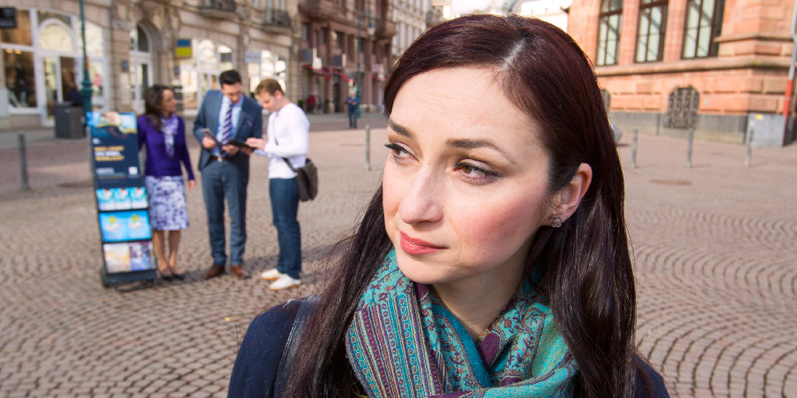 خانمی شاهدان یهوه را در حال موعظه عمومی در کنار چرخ‌دستی‌شان نگاه می‌کند