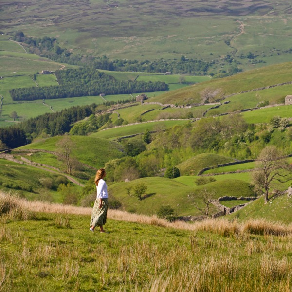 Une femme en train de marcher sur l’herbe dans un environnement paisible