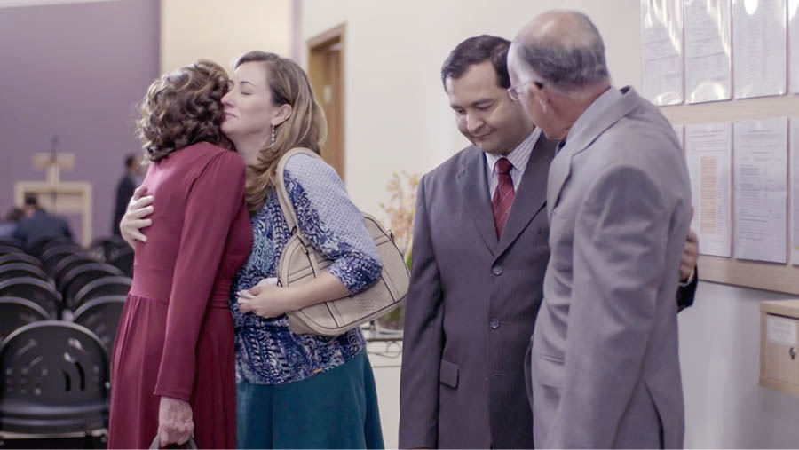 Image extraite de la vidéo « Restons fidèles d’un cœur complet ». Après une réunion de l’assemblée, des frères et sœurs prennent Gabriella et Ben dans leur bras pour les consoler.
