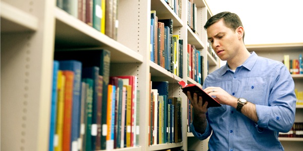 Lalaki nga adda iti libraria a mangsuksukimat iti Biblia