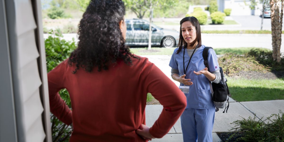 A professional caregiver talks to an angry woman