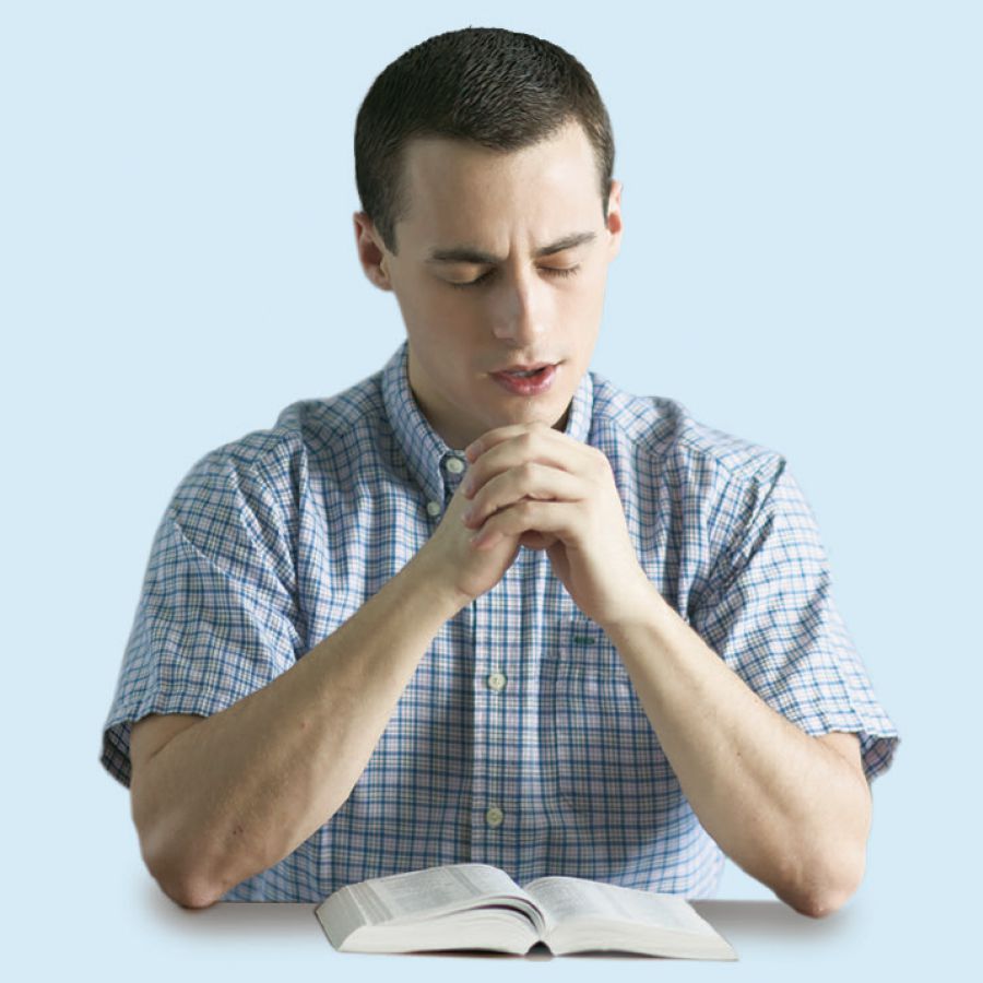 Un ragazzo che studia la Bibbia si dedica a Dio in preghiera