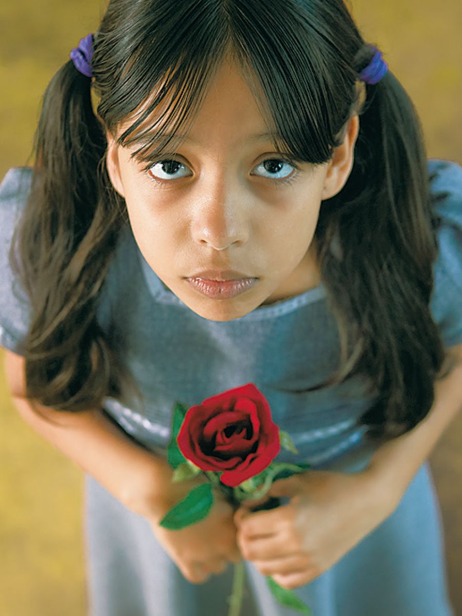 Una bambina tiene in mano una rosa