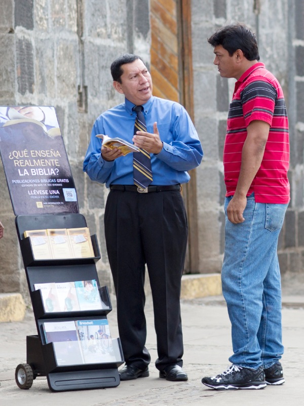 Testimone di Geova svolge l’opera pubblica con un espositore mobile