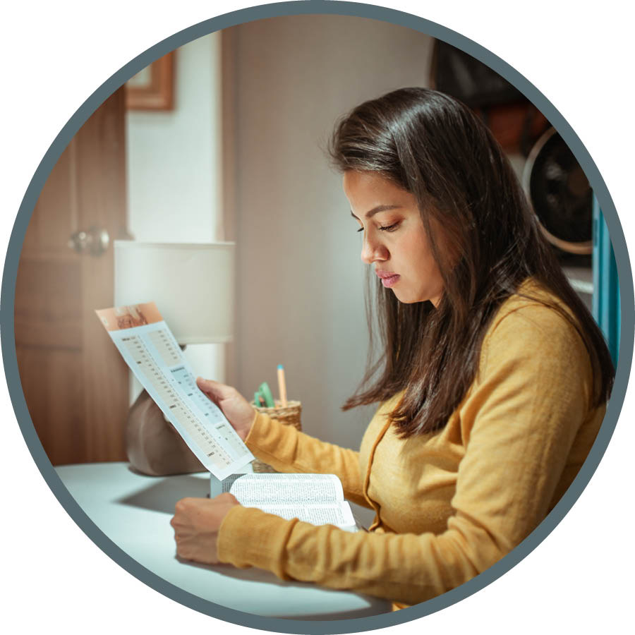 La donna legge la Bibbia mentre tiene in mano un programma per la lettura della Bibbia.