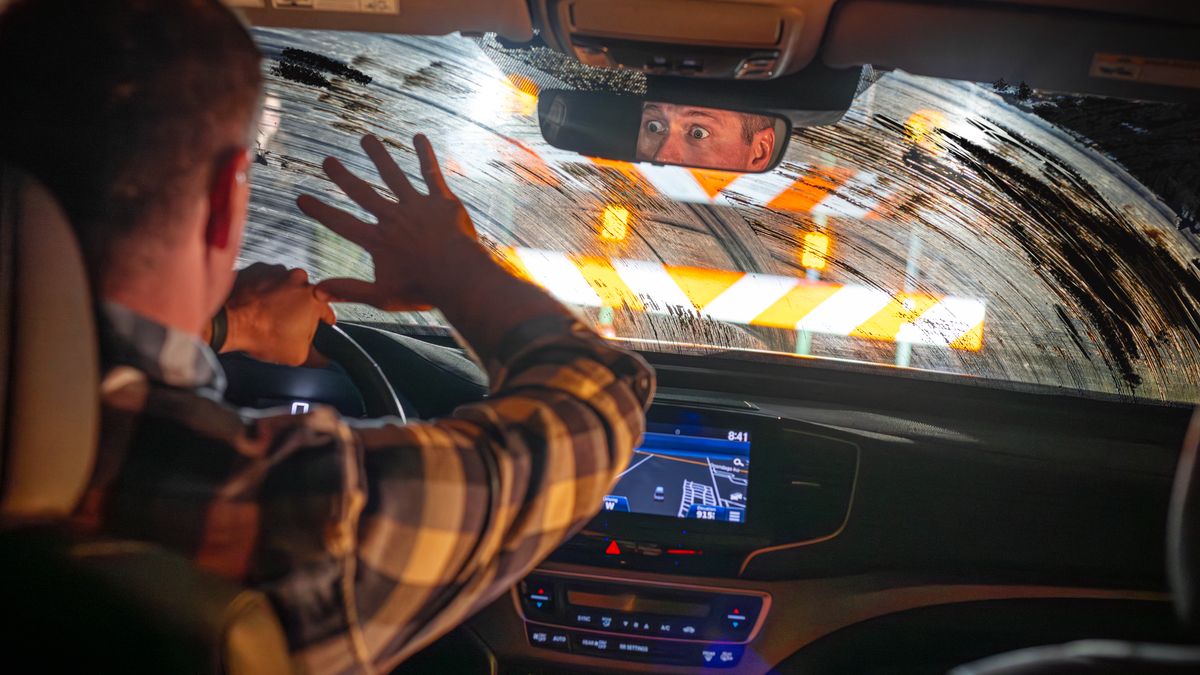 Un uomo che guida un’auto con il parabrezza sporco si ritrova all’improvviso un ostacolo davanti.