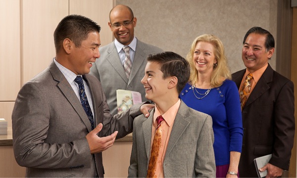 王国会館でベテル奉仕者と楽しく会話するジェイコブと両親
