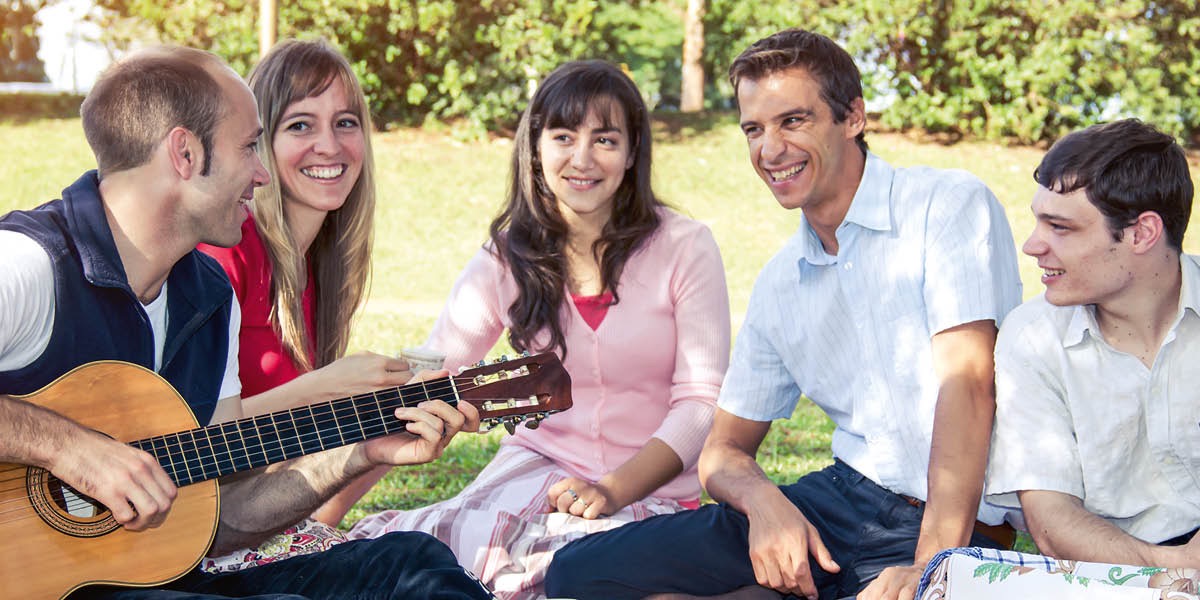 Na̱ hermano íyona nu̱ú iin parque ta sákaʼana iin guitarra ta xítana