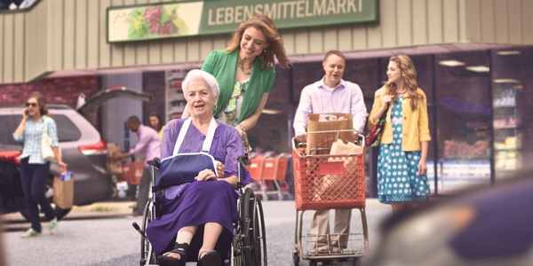 Volwassen kinderen doen boodschappen met hun moeder die in een rolstoel zit