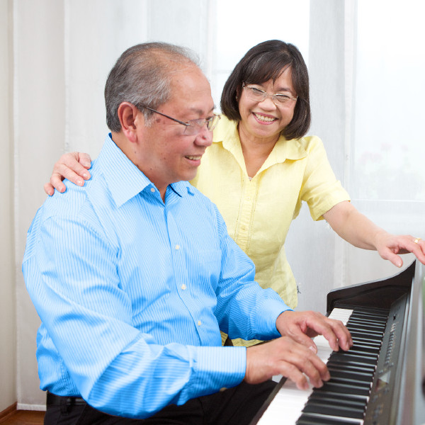 Een oudere man die piano speelt voor zijn vrouw