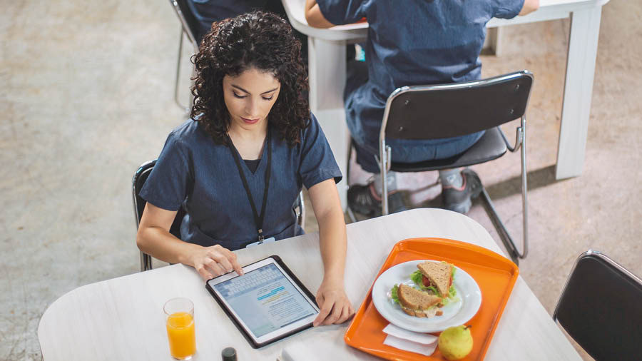 Dezelfde zuster gebruikt een tablet voor persoonlijke studie tijdens de lunchpauze op haar werk.
