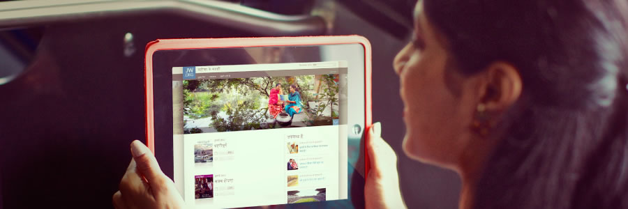 En dame som bruker jw.org på sin mobile enhet