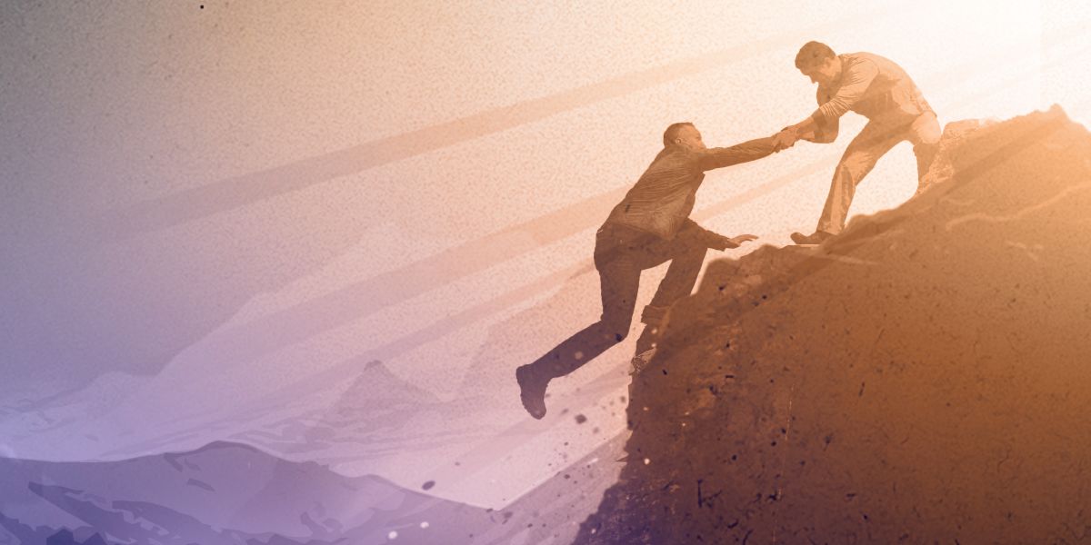 Человек едва не падает со скалы, но другой хватает его за руку и спасает