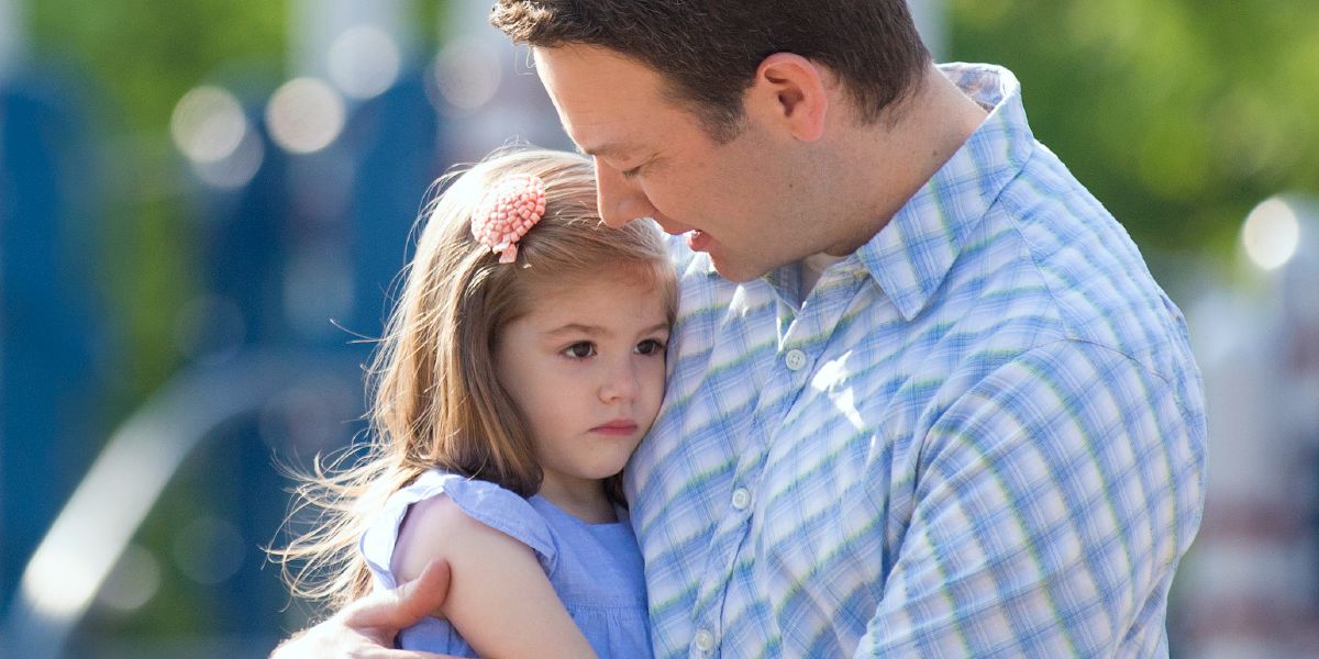 Отец держит на коленях дочку