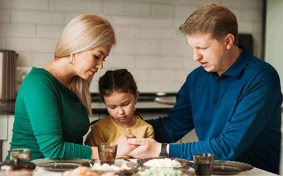 Семья молится перед едой.