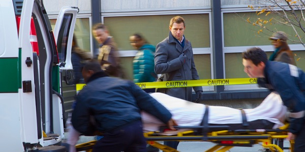 A person is lifted into an ambulance as passersby observe