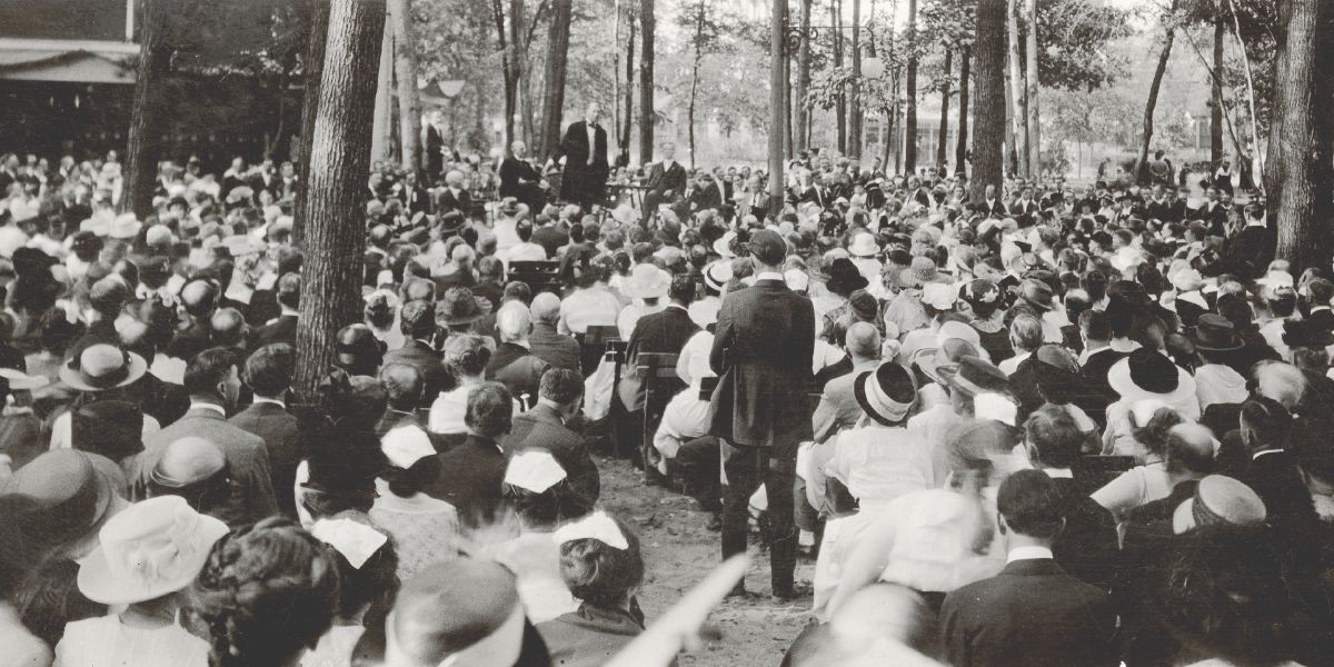 Xhozef Radhërfordi duke folur para një auditori të madh të ulur poshtë pemëve, në kongresin e Studentëve të Biblës të vitit 1919.