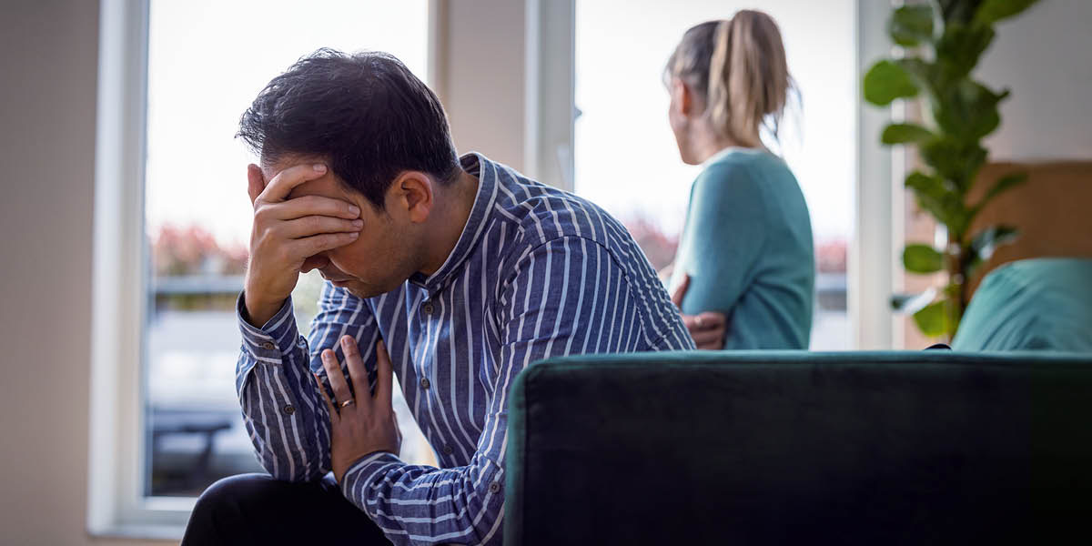 Monna ea soabileng o inamisitse hlooho ’me o itšoere phatleng, mosali oa hae eena o shebile ka ntle a le fensetereng.