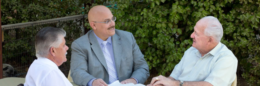 Two Christian brothers have a friendly visit with an elderly inactive Christian brother