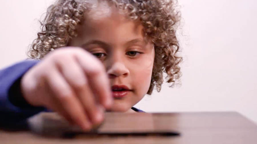 Setšoantšo se hlahang videong ea ‘Mpho Bakeng sa Jehova.’ Ngoana o tšela chelete ka lebokoseng la monehelo le holong ea ’muso.