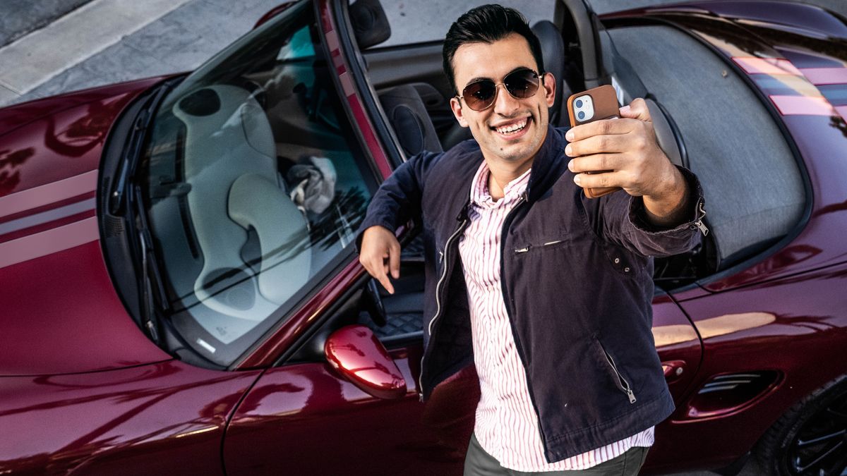 Mor’abo rona o nka selfie a eme pel’a koloi ea hae e turang.