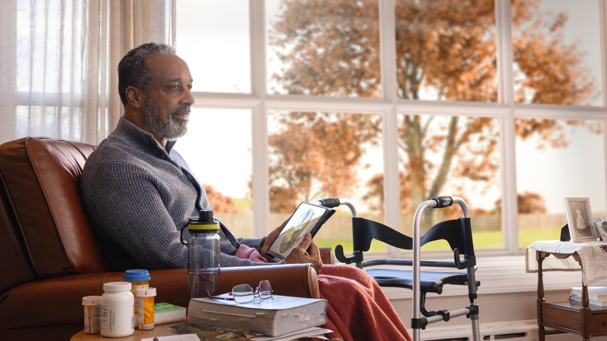 Mor’abo rona ea holileng o lutse ka tlung ea hae ka hoetla o ntse a nahana ka setšoantšo sa Paradeise se ho tablet ea hae. Pel’a hae ho na le seikokotlelo le libotlolo tsa lipilisi tse ’maloa.