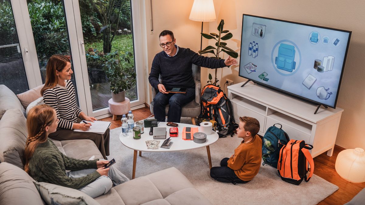 Ntate o ntse a khanna borapeli ba lelapa ’me o thusa mosali oa hae le bana ba hae ba babeli ho itokisetsa koluoa e ka ba amang sebakeng seo ba lulang ho sona. Ba shebeletse video ea “Na u Itokiselitse Likoluoa?” Ka pel’a bona ho na le libotlolo tsa metsi, chelete, Bibele, lijo tse ka mathining, theipi, mekotla ea tšohanyetso le lintho tse ling.