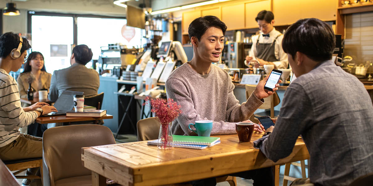 Mohlankana o bontša motsoalle oa hae ntho e hlahileng fonong.