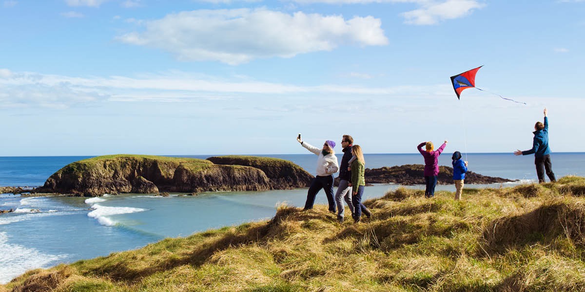Sababaraha jalma keur maén langlayangan jeung popotoan di basisir