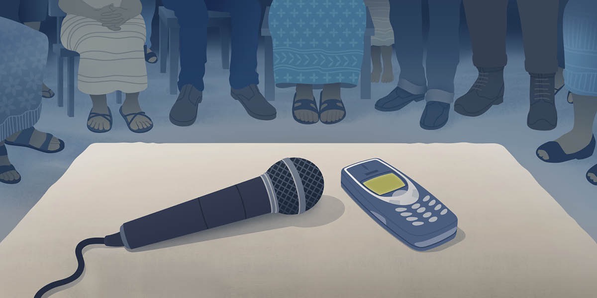 Jalma-jalma ngumpul pikeun diajar Alkitab liwat telepon. Di deukeut telepon, diteundeun mikrofon supaya sorana bisa kadéngé ku kabéhanana.