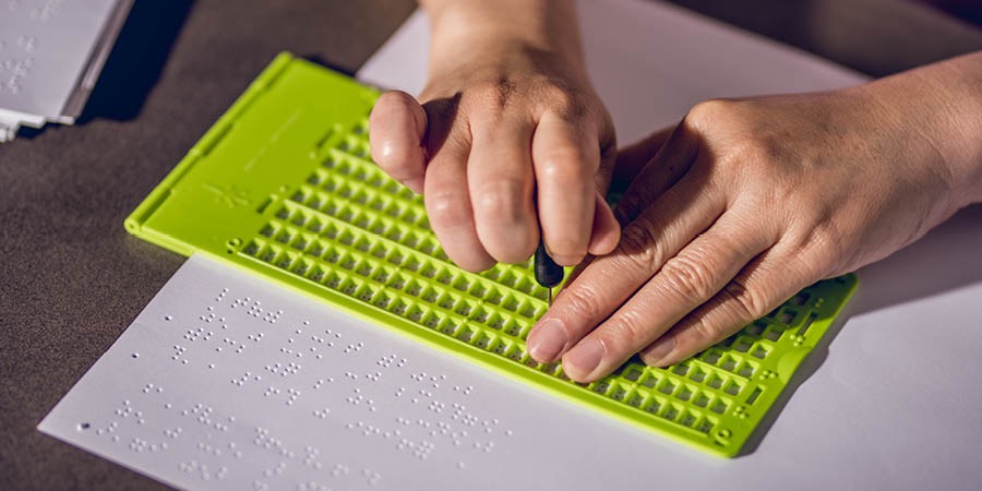 Narjamahkeun buku kana huruf braille ngagunakeun papan jeung alat nu jiga péna