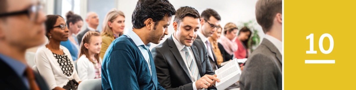 Bab 10. Dina acara ibadah Saksi-Saksi Yéhuwa, saurang lalaki maca Alkitab bareng jeung saurang Saksi.