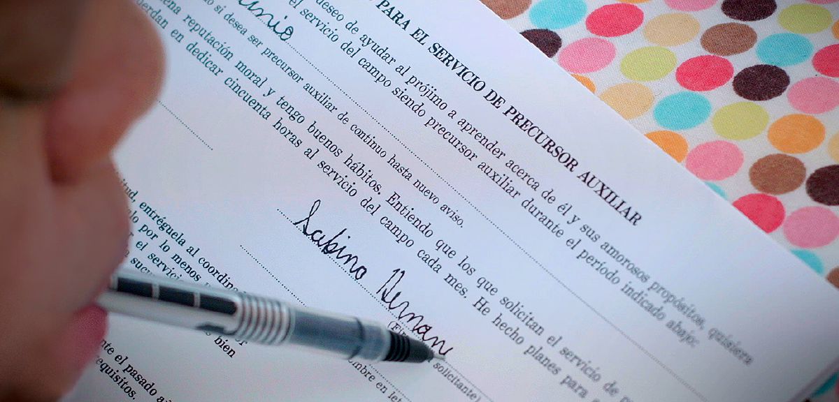 Sabina Hernández nyepeng pulpén ku sungutna pikeun nanda tangan formulir panaratas ékstra