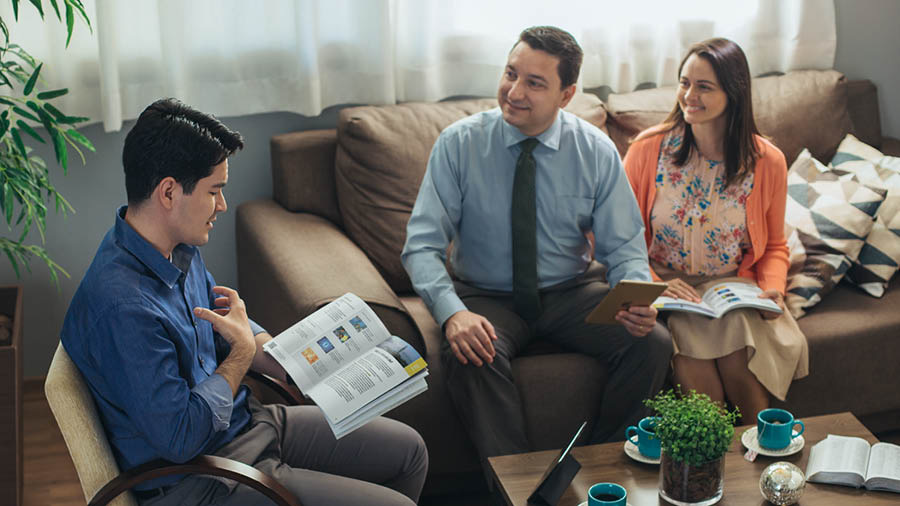 The same couple using the ”Enjoy Life Forever!” book to conduct a Bible study with the man at his home.