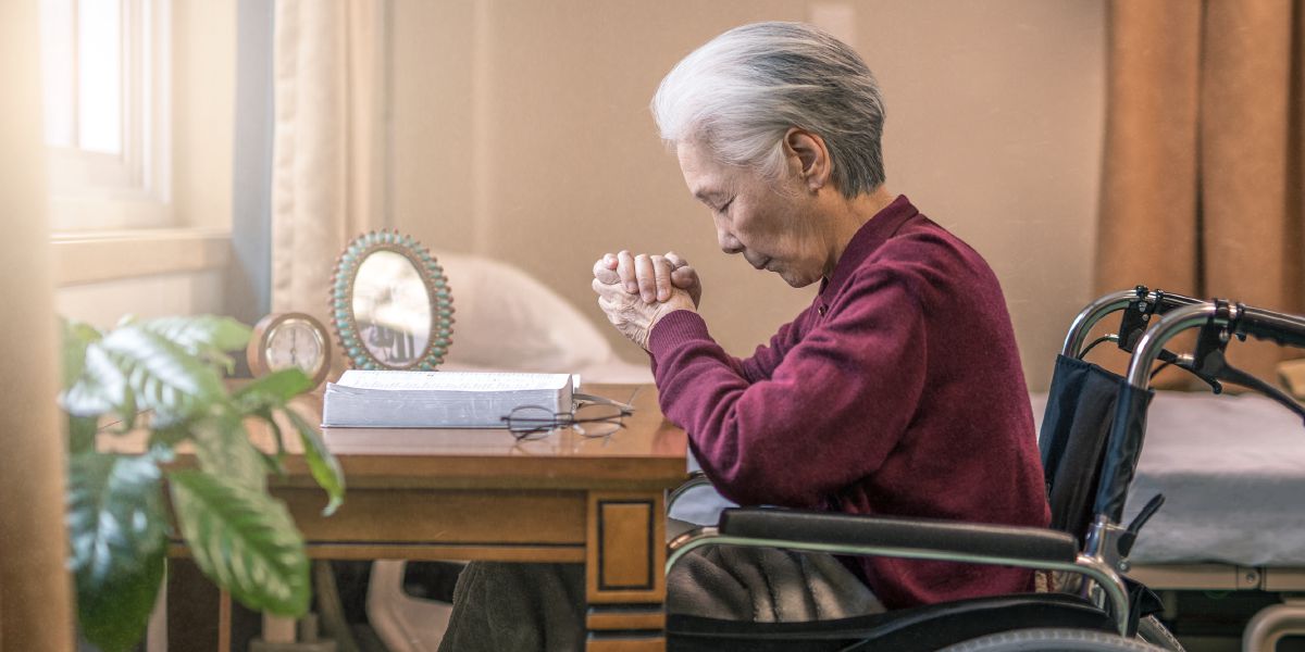 Saurang sadérék istri nu geus kolot keur ngadoa di korsi rodana