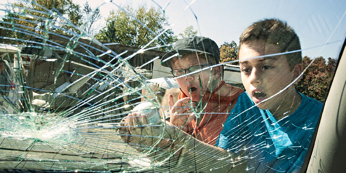 Dua budak lalaki olohok ningali kaca mobil nu peupeus