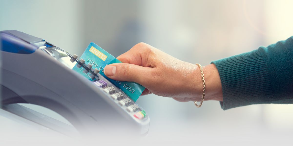 Bir kadın banka kartını pos makinesinden geçiriyor