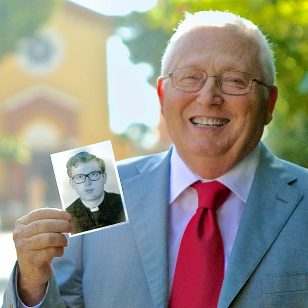 Antonio Della Gatta holds up a photograph of himself as a young priest